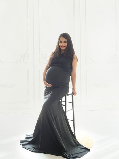 Wrapped in the elegance of black and white, this portrait celebrates the beauty of new life with grace and strength against a clean, minimalist backdrop.