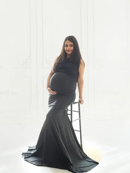 Wrapped in the elegance of black and white, this portrait celebrates the beauty of new life with grace and strength against a clean, minimalist backdrop.