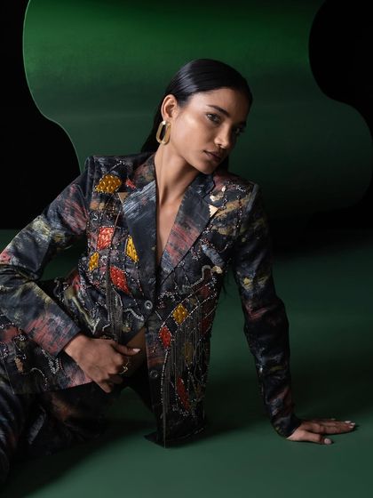 A duplicate of image 57, this shot from the Advait campaign showcases the detailed beadwork and rich colors of the blazer against a dark, moody background.