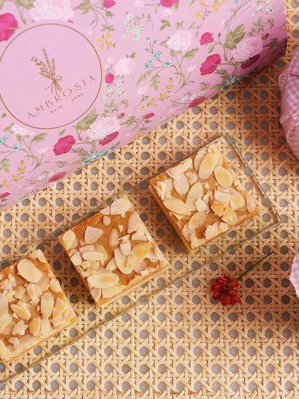 Our almond teacakes displayed next to our elegant pink floral gift box. Our customisable hampers add flavour and joy to every special occasion.