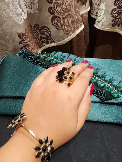 Getting ready for Diwali with the right accessories. This shot features a beautiful teal clutch with green embellishments, paired with a floral bracelet and ring.