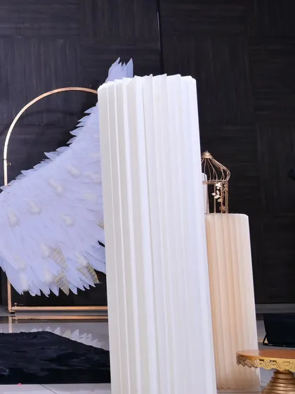 A view of the tall, white fluted pedestals used for displaying the cake or other key elements, complementing the clean and modern aesthetic.