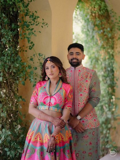 Bright hues and happy hearts at Sula Vineyards. This couple's vibrant, coordinated outfits by Siddhartha Bansal pop against the lush greenery of the Nashik venue, making for a stunning Haldi event portrait.