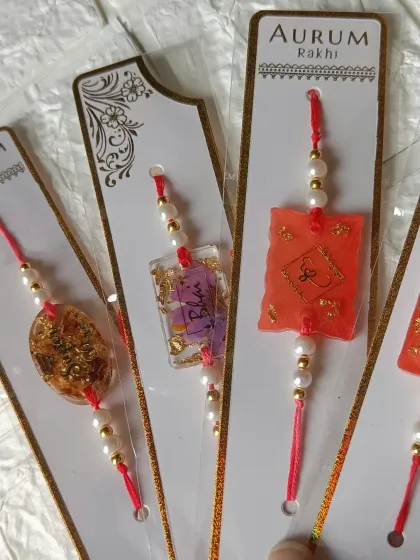 A variety of my handmade resin rakhis, featuring different colors, shapes, and gold leaf details. Each one is made with love for the special bond of Raksha Bandhan.