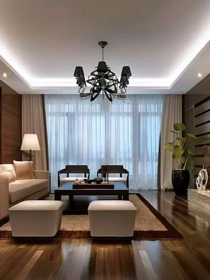 A formal living room design where we used dark wood paneling, a mirrored accent wall, and a statement chandelier to create a luxurious and dramatic atmosphere. The layout is perfect for sophisticated entertaining.