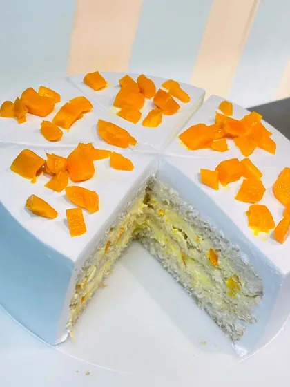 A slice of heaven! This image reveals the inside of our mango cake, with layers of light sponge and creamy mango filling.