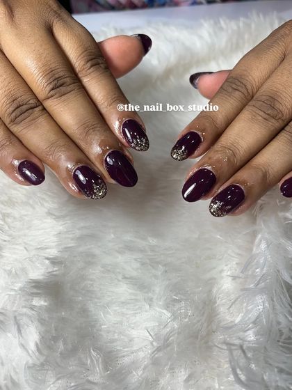 This almond-shaped soft gel extension set looks so chic with the dark plum color and the subtle gold glitter fade near the cuticle.
