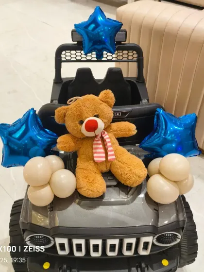 Even the birthday boys' ride-on car was decorated with balloons and a teddy bear to match the party theme!