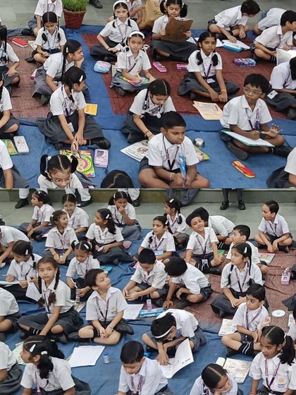 Young participants of the 2024 Olympiad at Gayatri Public School, sitting on the floor and engrossed in their creative and academic tasks.