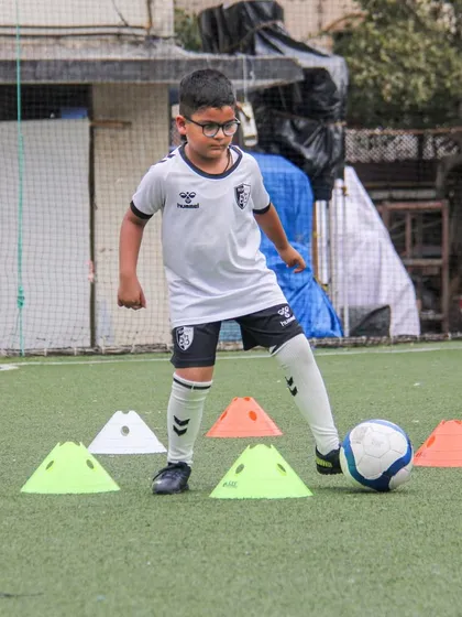 Concentration is key as this young athlete works his way through a complex cone pattern, a drill designed to test and improve his focus and dribbling precision.