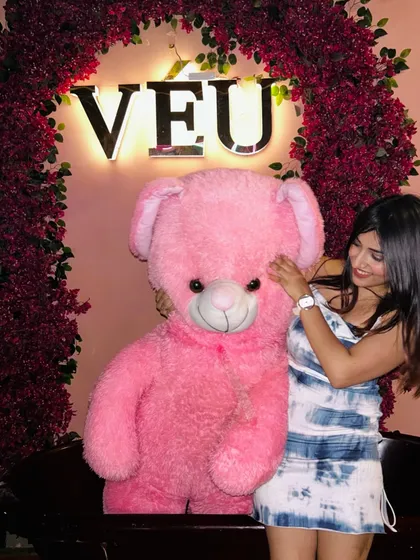 Posing with a giant pink teddy bear at Veu. This is a fun, Instagrammable moment that my followers love.