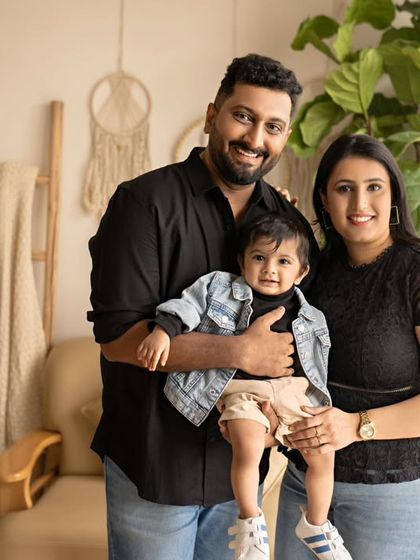 A happy family of three, dressed in stylish black and denim.