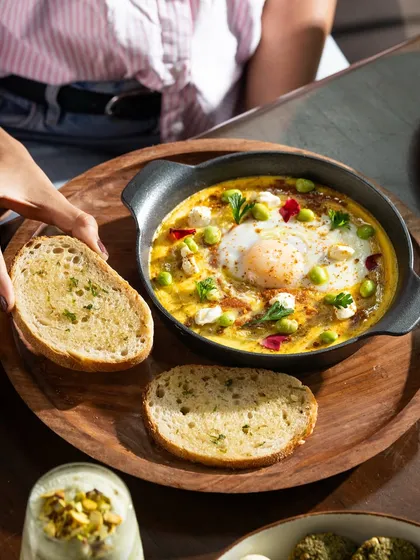 Shakshuka with garlic bread for dipping. This shot is all about comfort and warmth, perfect for a hearty breakfast.