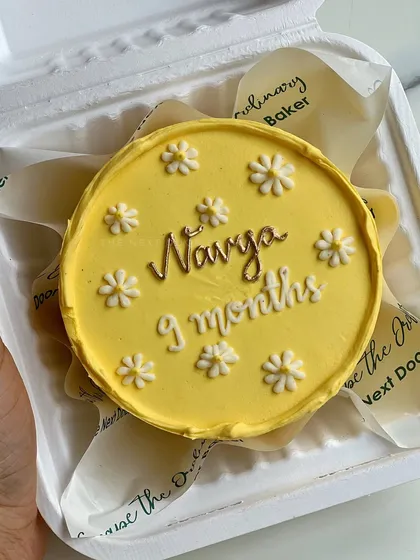 Celebrating a 9-month milestone with this sunny yellow mini cake decorated with tiny white daisies. These monthly cakes are a sweet way to mark a baby's growth.