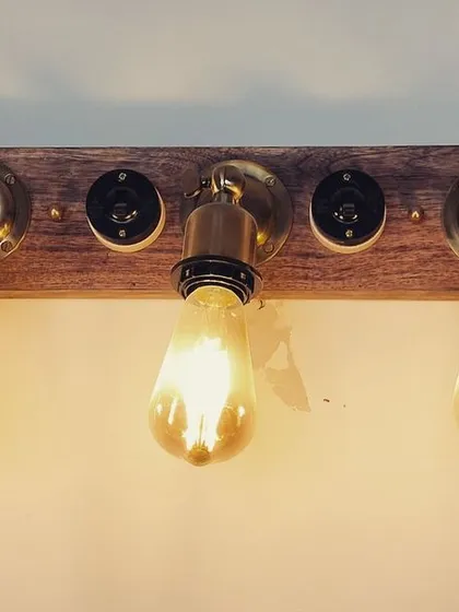 For a more industrial or rustic vibe, I often use custom fixtures like this vanity light. The combination of a warm wood base, brass fittings, and exposed Edison bulbs provides a warm, ambient glow that is perfect for cafes, bars, or boutique hotel restrooms.
