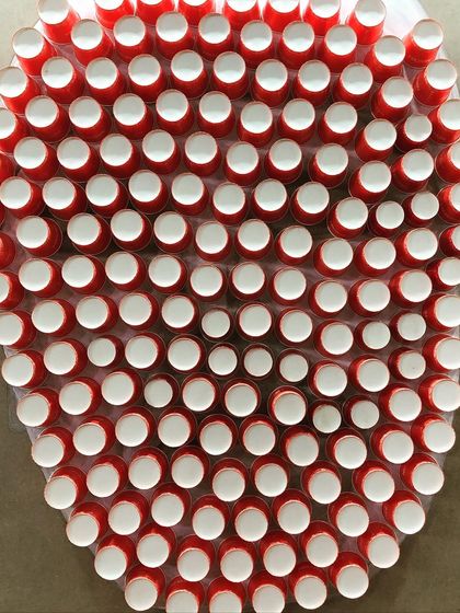 As a tribute to coffee farmers, this portrait was created live at the World Coffee Conference using waste from the Nescafé stall. The face is formed from used paper cups, and the background is a mosaic of empty coffee sachets contributed by visitors, making it a truly collaborative and sustainable piece.