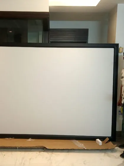 Here I am with a large fixed-frame projector screen just before installation. I am personally involved in every project to bring the best audio-visual experience to your space.