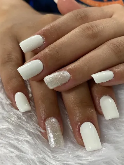 A clean and classic all-white manicure with a touch of sparkle. The glitter accent nail adds just the right amount of glamour to this fresh look.