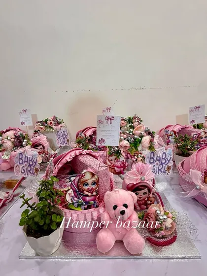 It's a girl! We love creating these adorable pink-themed pram hampers to welcome a little princess. This one includes a cute teddy, a live plant, and sweet treats, all arranged on a beautiful MDF base.