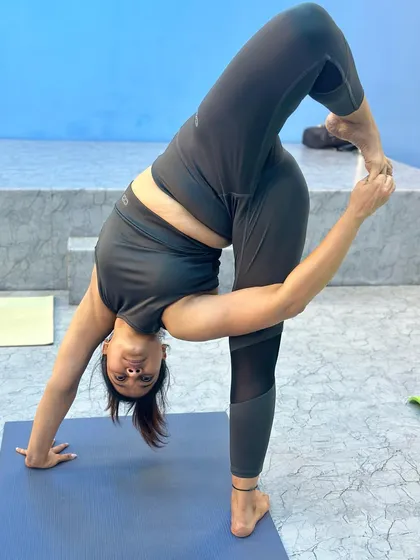 A student in a deep standing forward bend variation. Following simple steps in your daily routine is the key to progress.