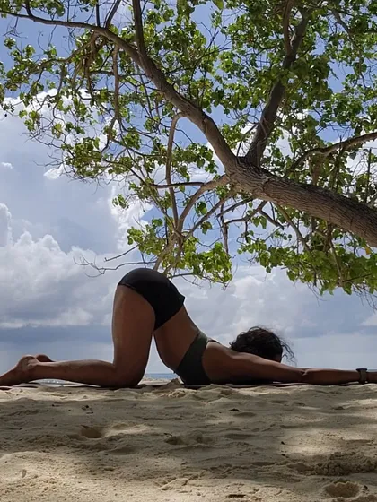 Life is beautiful. A gentle heart-opening pose on the sand, connecting with the earth and the sky.