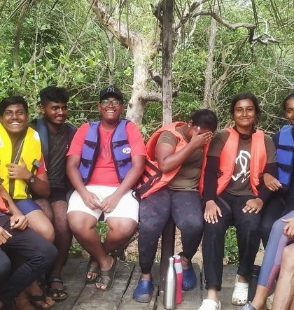 A group of friends huddles together for a photo during a boat ride at the Karwar camp.