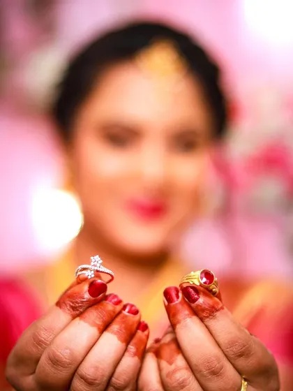 A beautifully composed photo focusing on the engagement rings held by the bride. The soft, blurry background keeps the attention on this important detail.