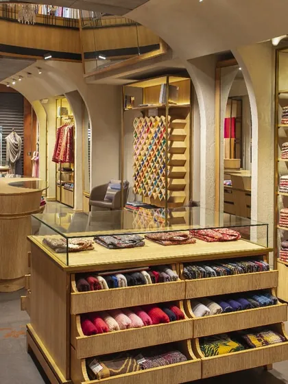 The display furniture at Ahujasons is entirely bespoke, designed to showcase the products beautifully and functionally. This glass-topped counter with pull-out drawers allows for easy viewing of delicate shawls and scarves, blending aesthetics with practical retail needs.