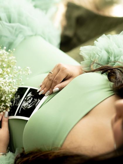 A close-up, artistic shot of the mother-to-be holding her sonogram picture and a bouquet of baby's breath.
