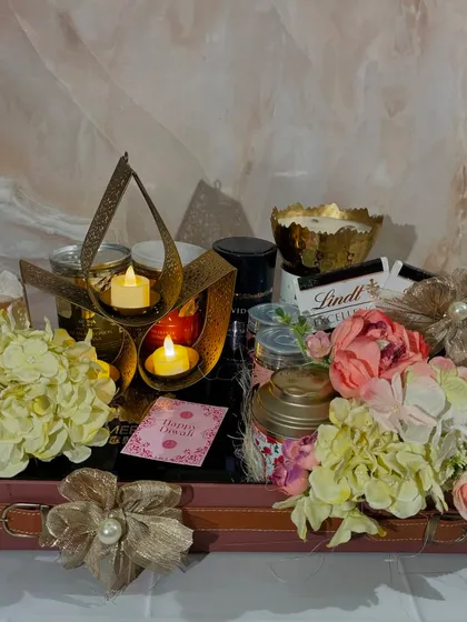 Brighten up your Diwali with our Lotus Lit Hamper. This leatherette trunk is packed with decorative candles, tea, coffee, mithai, Lindt chocolates, and other gourmet nuts and snacks.
