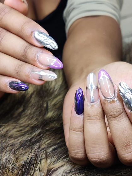 A bold, futuristic look featuring sculpted, three-dimensional liquid silver chrome details on long, clear almond-shaped extensions.