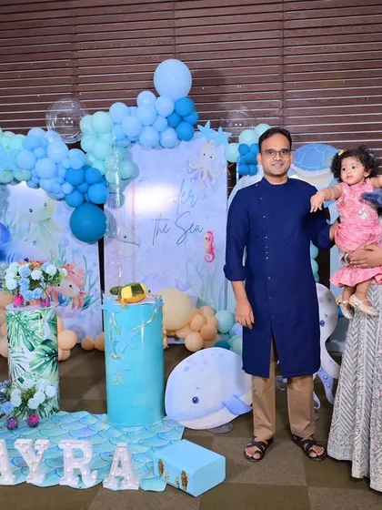 A happy family photo with the birthday girl in front of the beautiful underwater-themed backdrop I created for them.