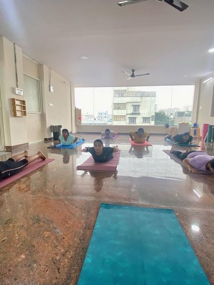 Students practicing Salabhasana (Locust Pose), a backbend that strengthens the muscles of the spine, buttocks, and backs of the arms and legs.