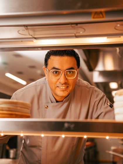 A peek from the pass. Chef Dhiraj keeps a watchful eye, ensuring every dish that leaves the kitchen is perfect.