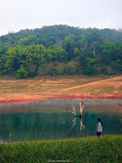 A serene moment by the water in Wayanad, with lush green hills in the background. Our trips offer a perfect blend of adventure and tranquility.