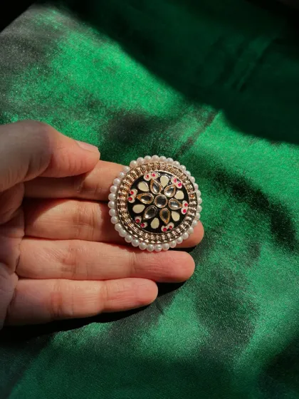 A Kundan and Meenakari statement ring with a pearl border.