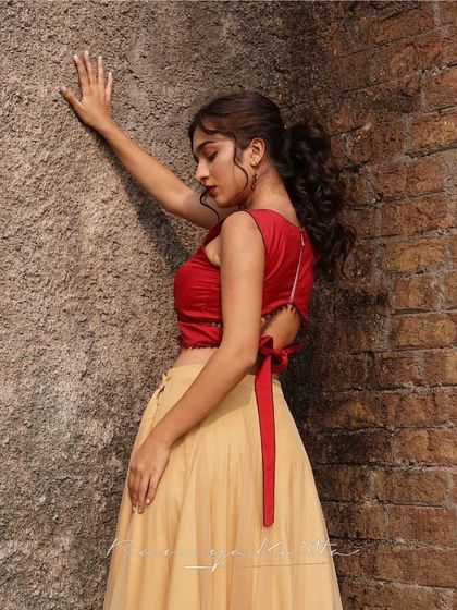 The tie-back detail of the red crop top adds a modern and playful element to this chic ensemble.