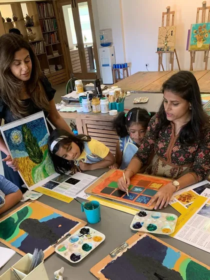 We bring art history to life by studying the masters up close. Here, we are discussing Vincent van Gogh's use of color and texture before the students begin their own post-impressionist landscapes. Our classes are interactive, making learning about art engaging and fun.