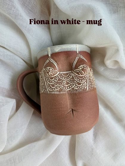 The 'Fiona' mug in white from the Déesse Collection. The design is softer, reflecting a different personality, but with the same attention to hand-carved detail that defines these pieces.