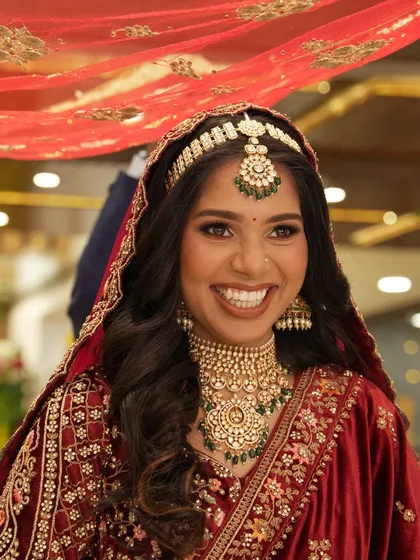 A radiant bride with a beautiful, wide smile, captured during her wedding ceremony.