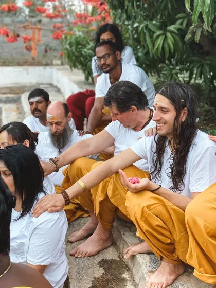 Students sit on the steps during a water ceremony, connecting with the element of water as a symbol of flow, cleansing, and emotion.