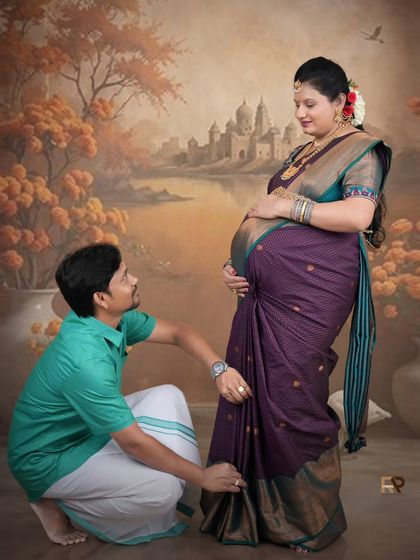 A loving moment captured during a traditional maternity session. The father-to-be helps adjust his wife's saree, a small, intimate gesture that speaks volumes.