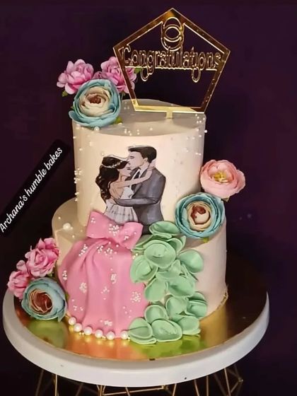A beautiful two-tiered congratulations cake with an edible print of a couple and lovely sugar flowers.