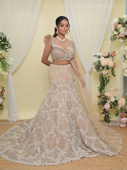 A full-length view of the stunning fish-cut lehenga. The makeup is kept soft and glamorous to complement the modern silhouette and intricate beadwork of the outfit.