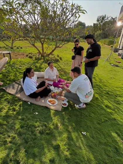 A glimpse of my team setting up for a picnic scene during an outdoor shoot. Collaboration is key, and here we are arranging props and discussing the composition to create a perfect lifestyle moment.