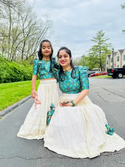 Another beautiful shot of this mother-daughter duo in their custom twinning outfits. The puff sleeves and printed fabric create a stylish, coordinated look.