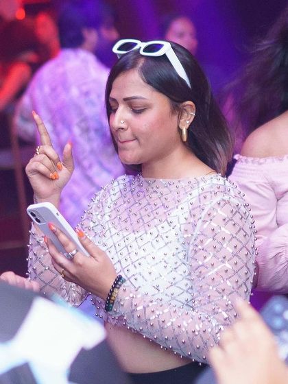 Checking the phone but still in the party mood. The vibe is too good to miss.