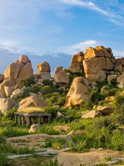 The surreal landscape of Hampi, with its giant boulders and ancient ruins dotting the green fields.