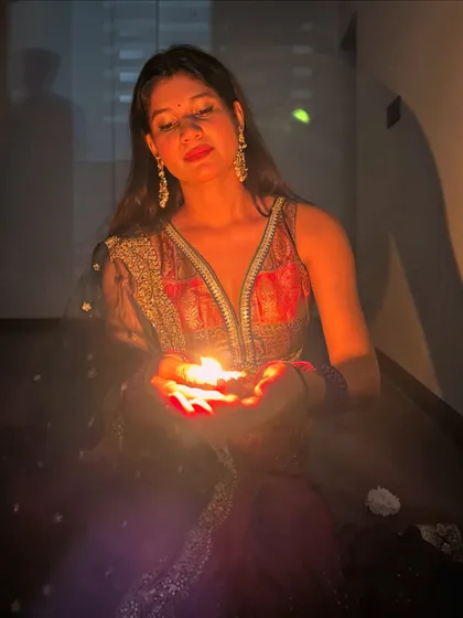 Holding a diya, the light illuminates the rich colors and intricate details of my Diwali outfit. Festive styling is about embracing tradition and celebrating with light and color.