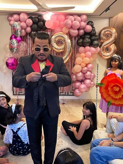 Getting ready for the next big surprise. A slight adjustment of my jacket is all part of the showmanship before I reveal the next illusion to the eager birthday party audience.